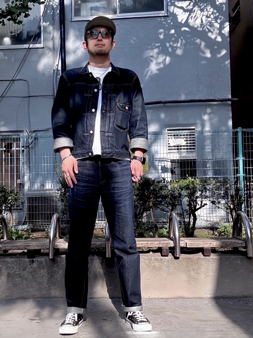 ブルー系のデニムパンツ、ブルー系のデニムジャケット、ブラック系のスニーカーを着用したメンズの春コーディネートの1枚目の写真