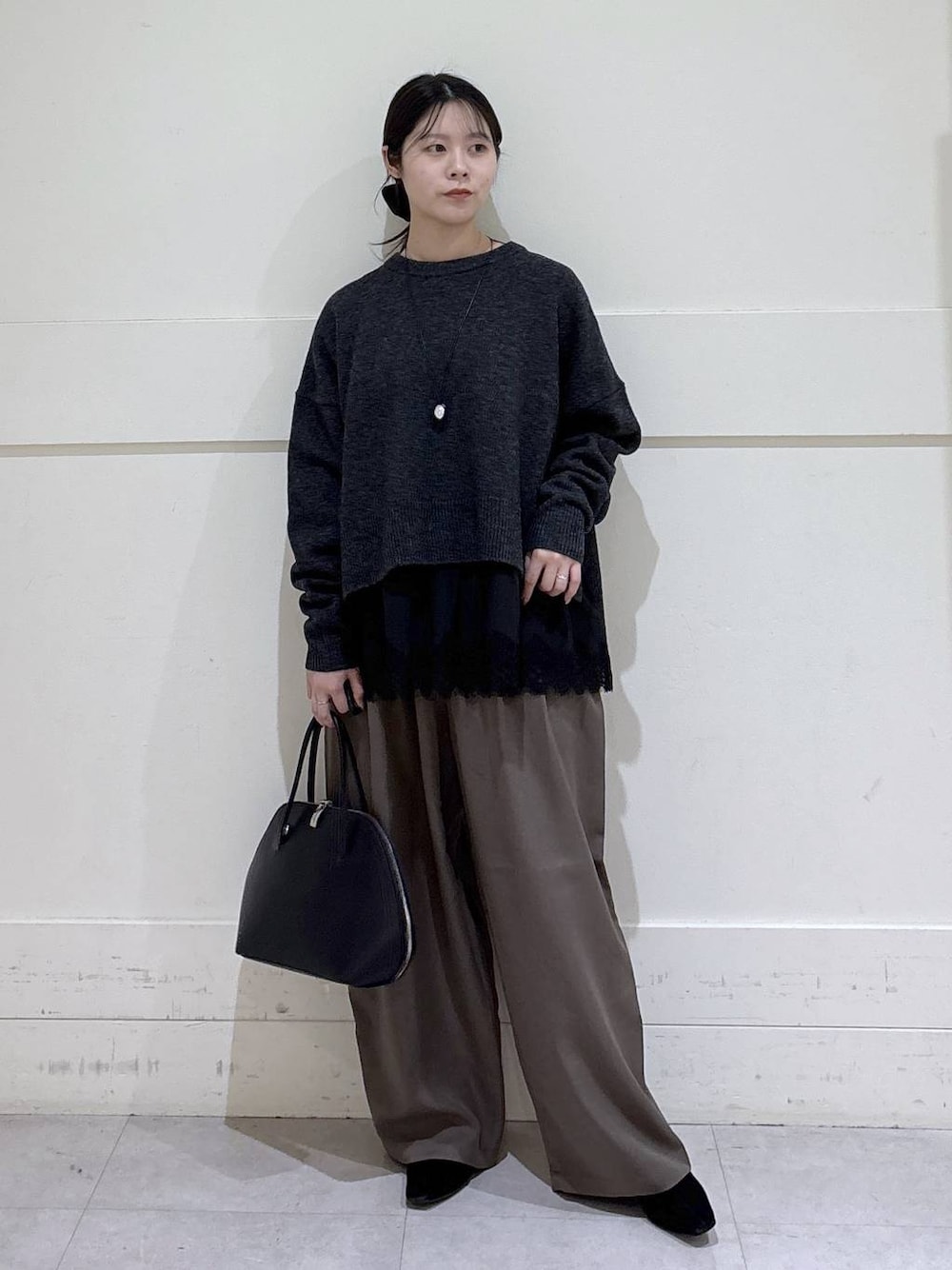 ブラック系のトートバッグ、ブラウン系のスラックス、ブラック系のシャツ/ブラウスを着用したレディースの冬コーディネートの1枚目の写真