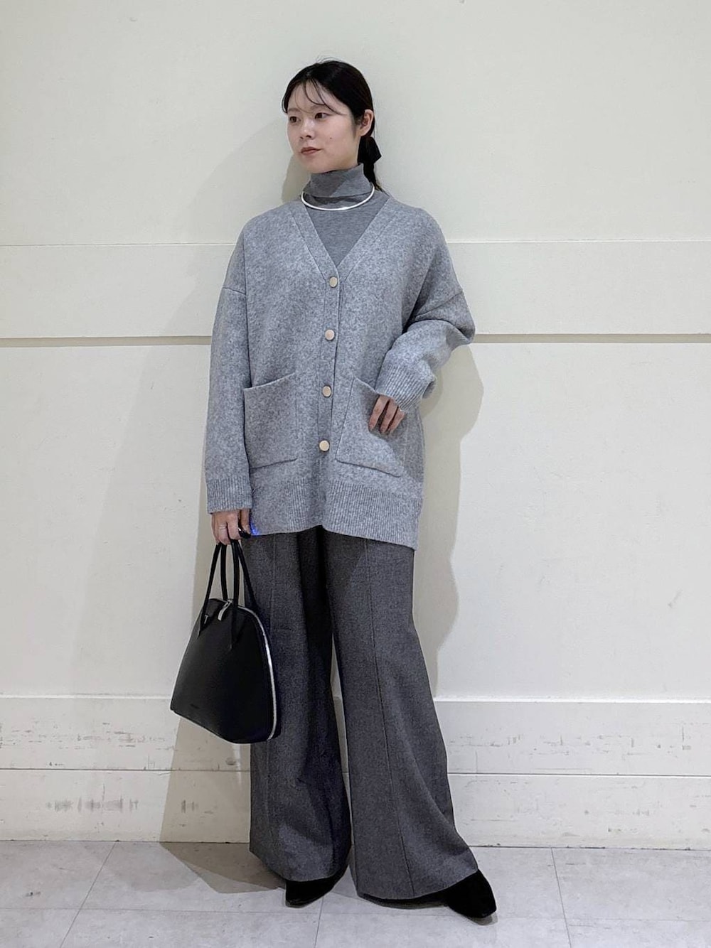 ブラック系のトートバッグ、グレー系のニット/セーター、グレー系のカーディガン/ボレロを着用したレディースの冬コーディネートの1枚目の写真