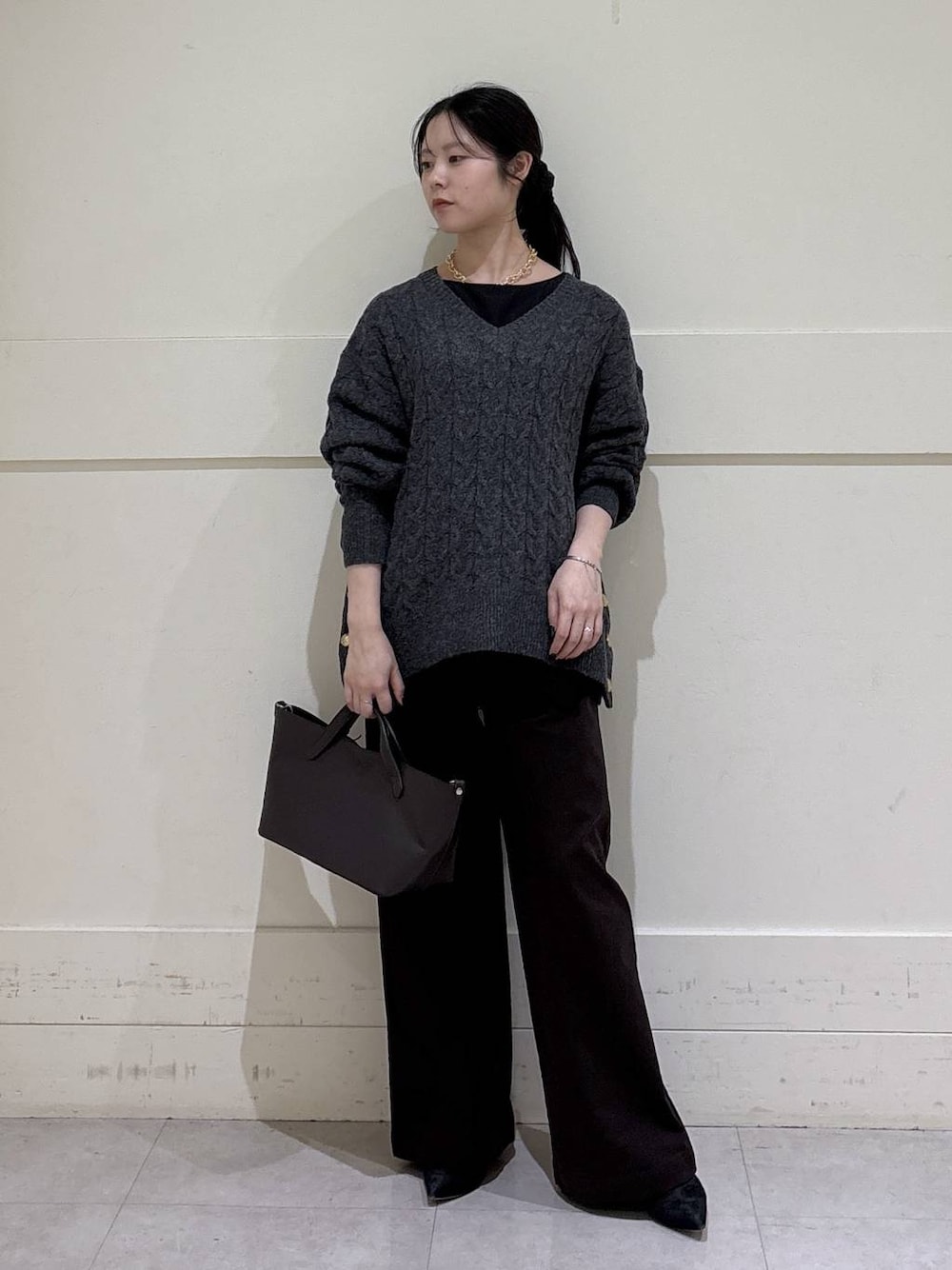 ブラック系のシャツ/ブラウス、グレー系のニット/セーター、ブラウン系のショルダーバッグを着用したレディースの秋コーディネートの1枚目の写真