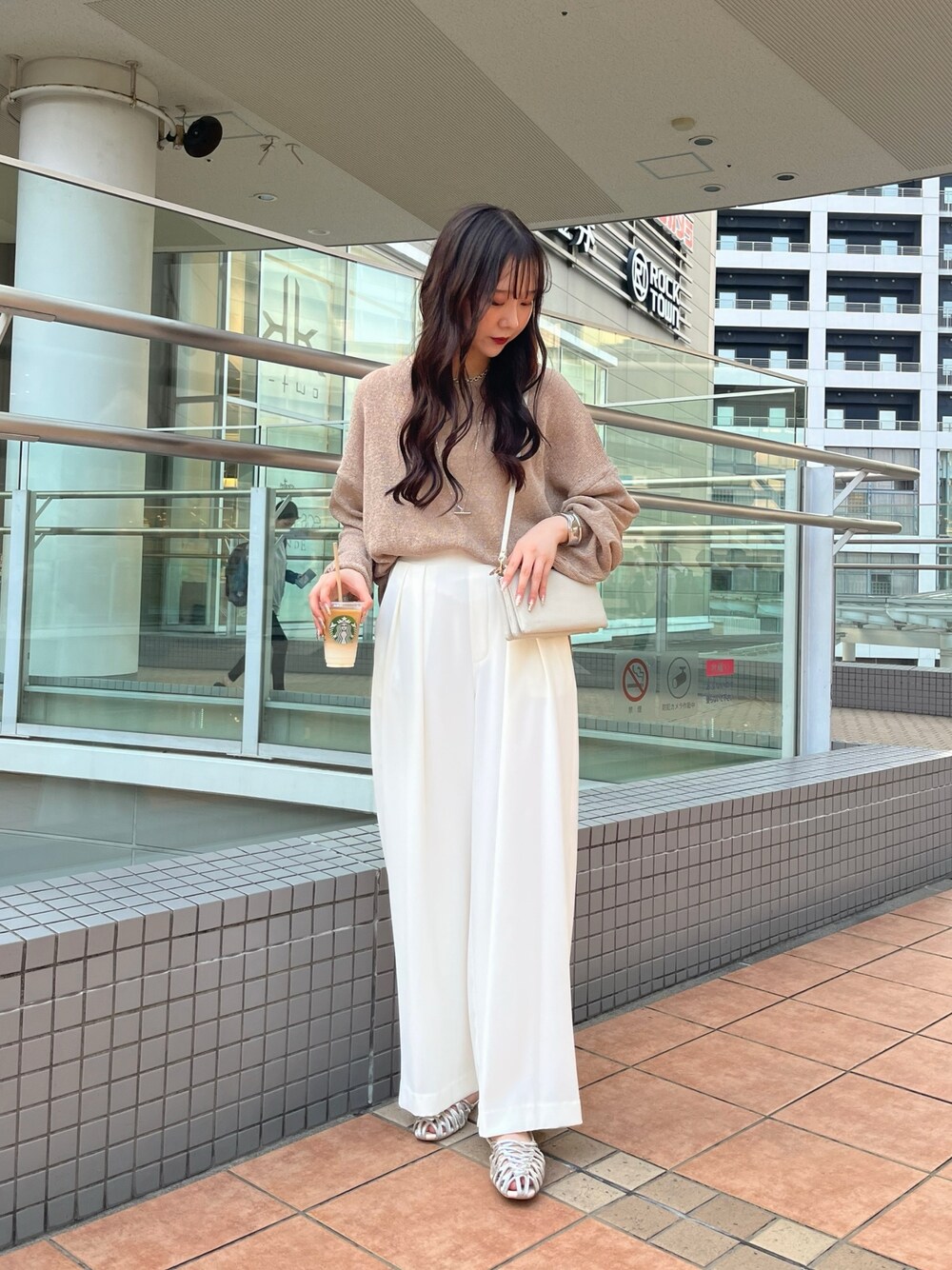 ブラウン系のニット/セーター、ホワイト系のスラックス、シルバー系のパンプスを着用したレディースの夏コーディネートの1枚目の写真