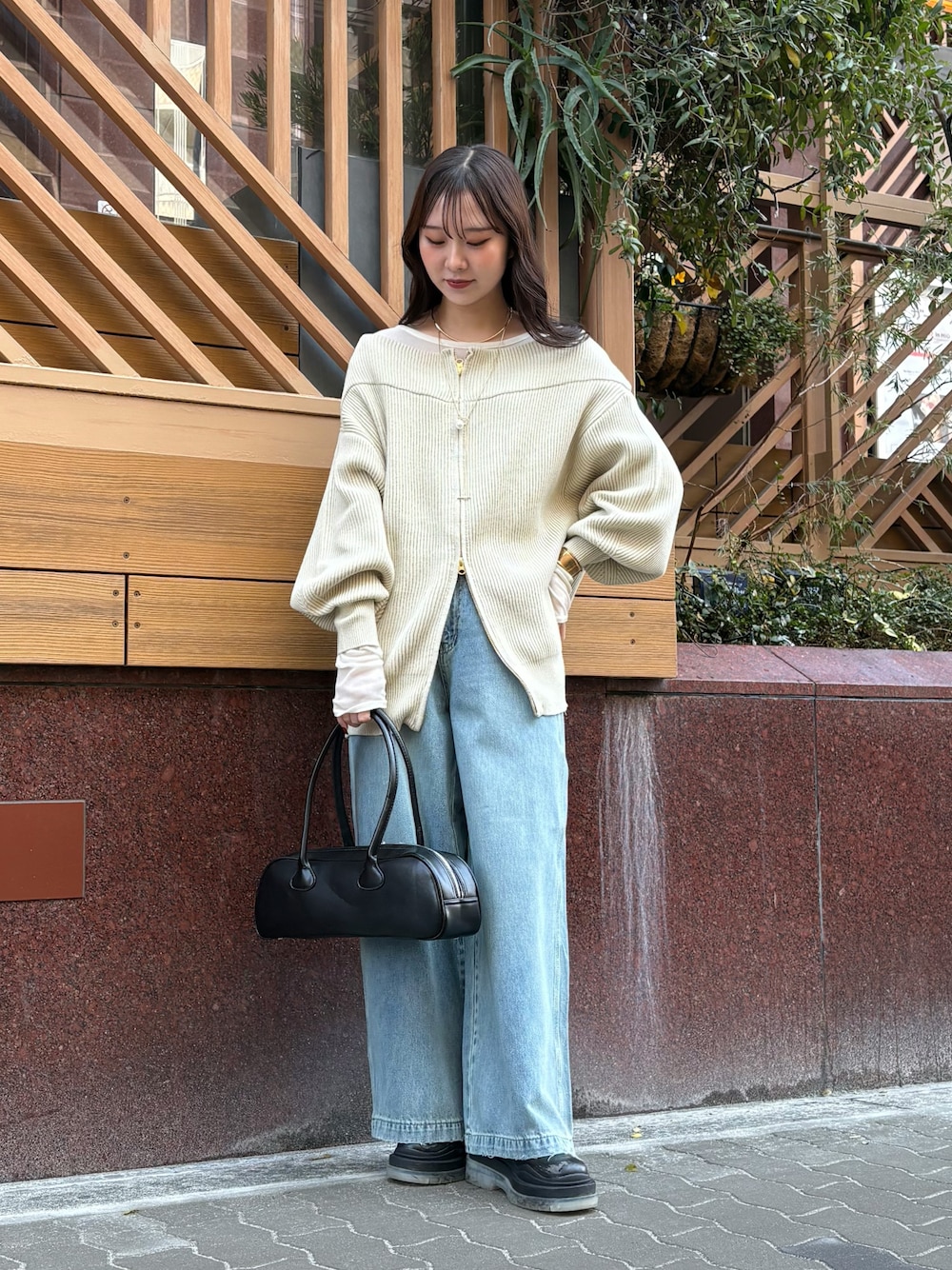 ブルー系のデニムパンツ、ブラック系のショルダーバッグ、ベージュ系のニット/セーターを着用したレディースの冬コーディネートの1枚目の写真