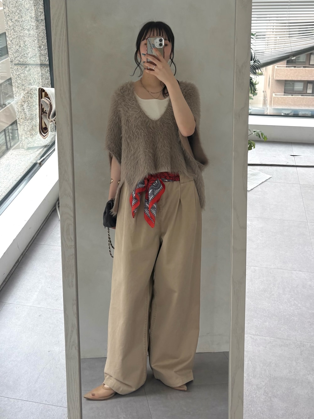 ベージュ系のチノパンツ、ベージュ系のニット/セーター、ホワイト系のタンクトップを着用したレディースの秋コーディネートの1枚目の写真