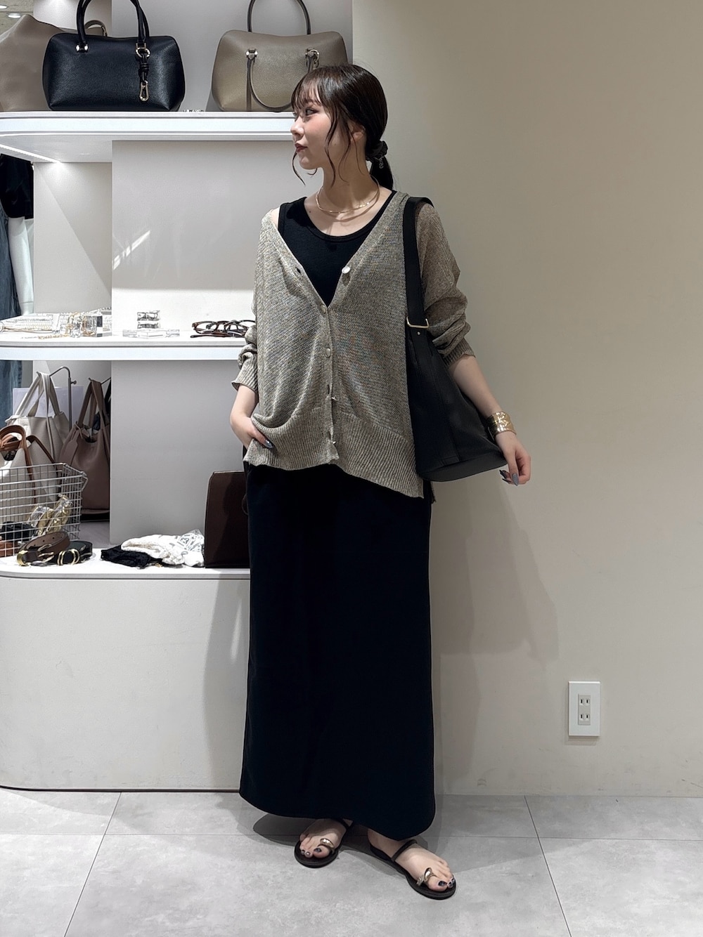 ブラック系のワンピース、ベージュ系のカーディガン/ボレロ、ブラック系のショルダーバッグを着用したレディースの夏コーディネートの1枚目の写真