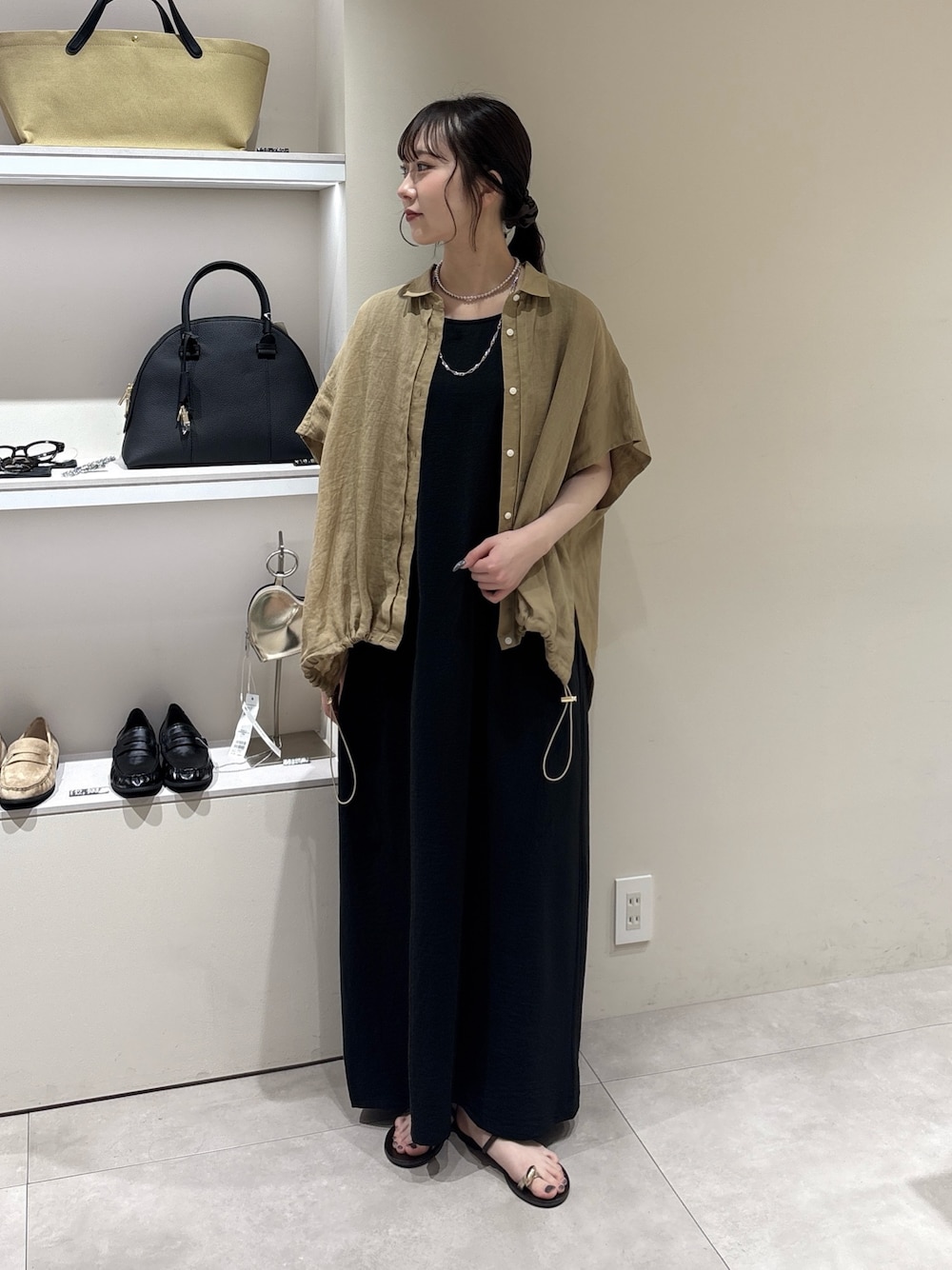 ブラック系のワンピース、ベージュ系のシャツ/ブラウス、シルバー系のネックレスを着用したレディースの夏コーディネートの1枚目の写真