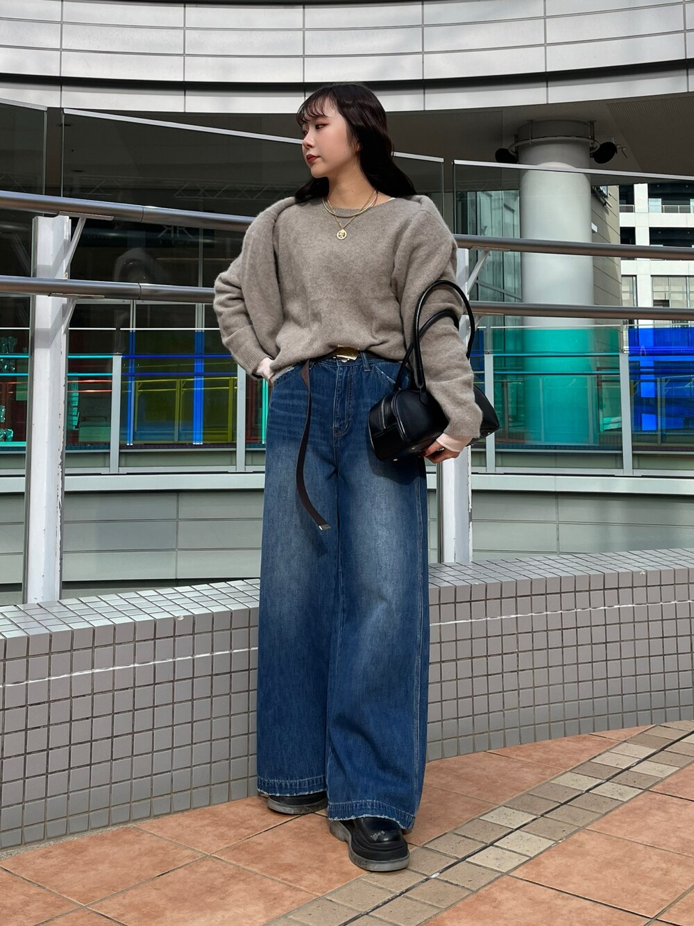 ブルー系のデニムパンツ、ブラウン系のニット/セーター、ブラウン系のカーディガン/ボレロを着用したレディースの冬コーディネートの1枚目の写真