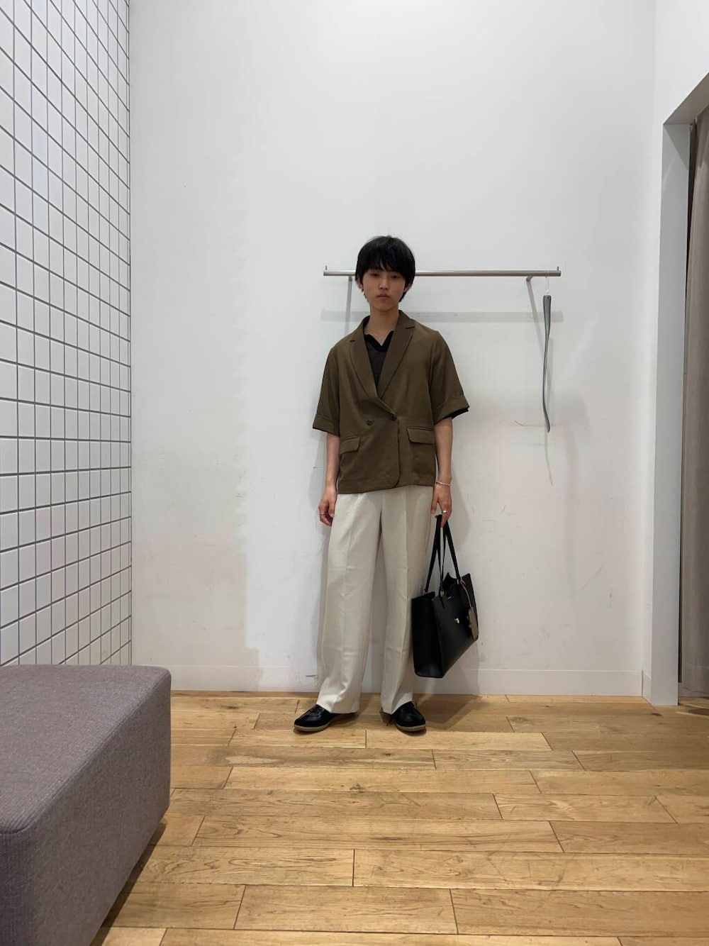 ブラック系のスニーカー、ブラック系のトートバッグ、ベージュ系のその他パンツを着用したメンズの春コーディネートの1枚目の写真