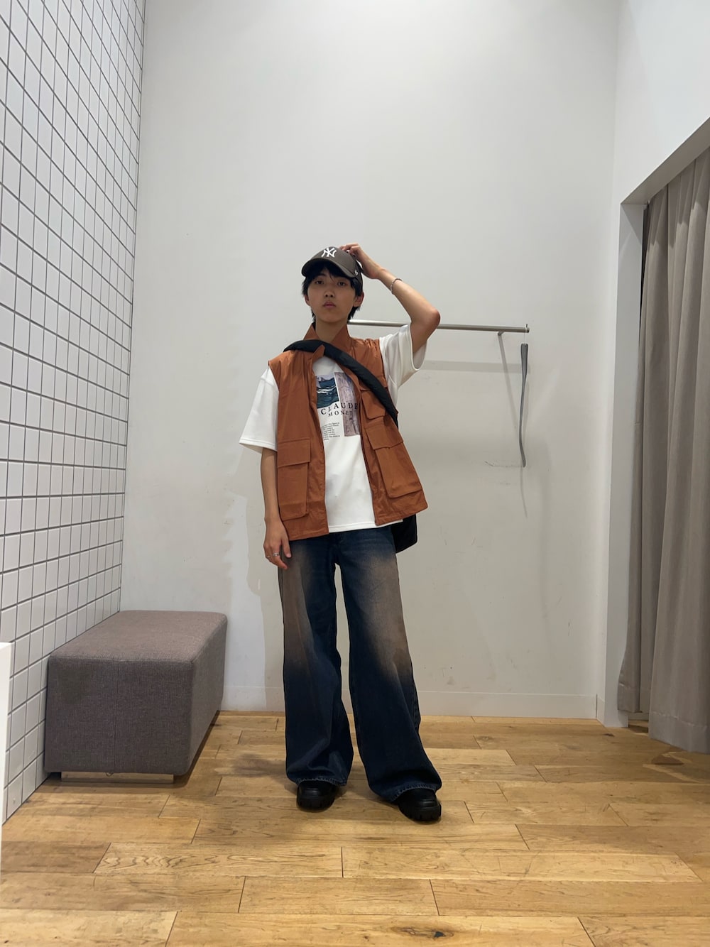 ブラック系のショルダーバッグ、ホワイト系のTシャツ/カットソー、オレンジ系のブルゾンを着用したメンズの秋コーディネートの1枚目の写真