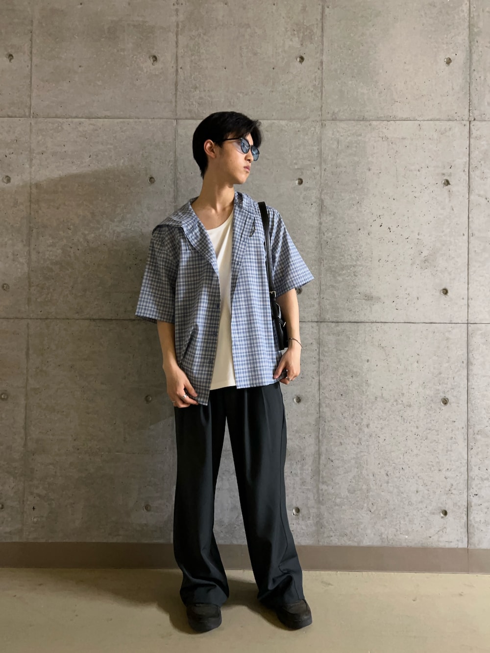 グレー系のその他パンツ、ホワイト系のタンクトップ、ブラック系のショルダーバッグを着用したメンズの春コーディネートの1枚目の写真