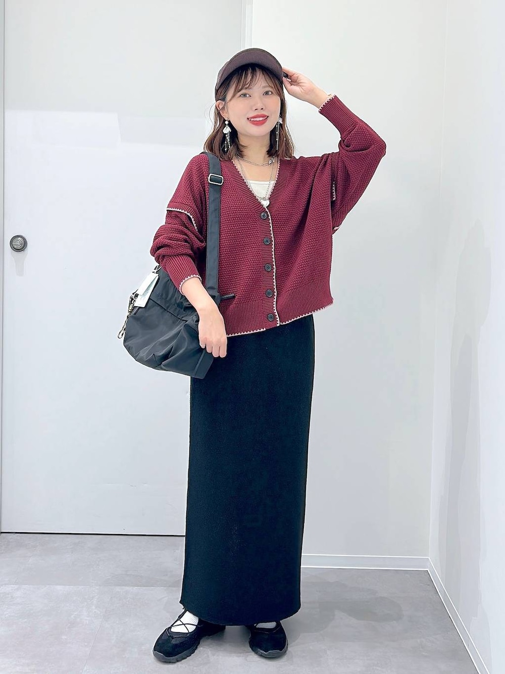 ブラック系のスニーカー、ブラック系のショルダーバッグ、レッド系のカーディガン/ボレロを着用したレディースの秋コーディネートの1枚目の写真