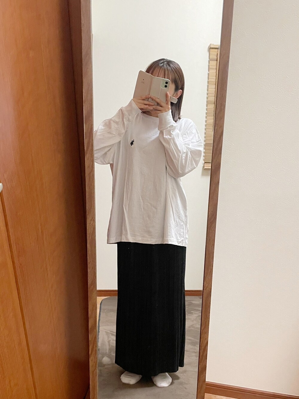 ブラック系のスカート、ホワイト系のTシャツ/カットソーを着用したレディースの秋コーディネートの1枚目の写真