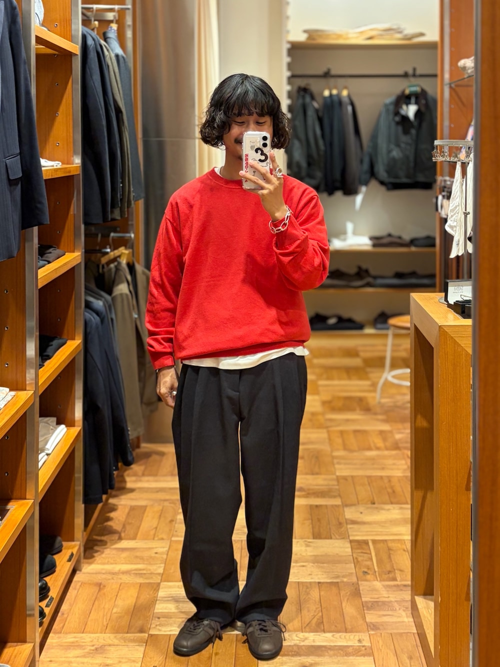 レッド系のニット/セーター、グレー系のその他パンツを着用したメンズの秋コーディネートの1枚目の写真
