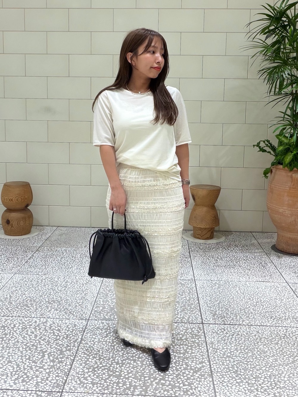 ホワイト系のTシャツ/カットソー、ホワイト系のスカート、ブラック系のバッグを着用したレディースの夏コーディネートの1枚目の写真