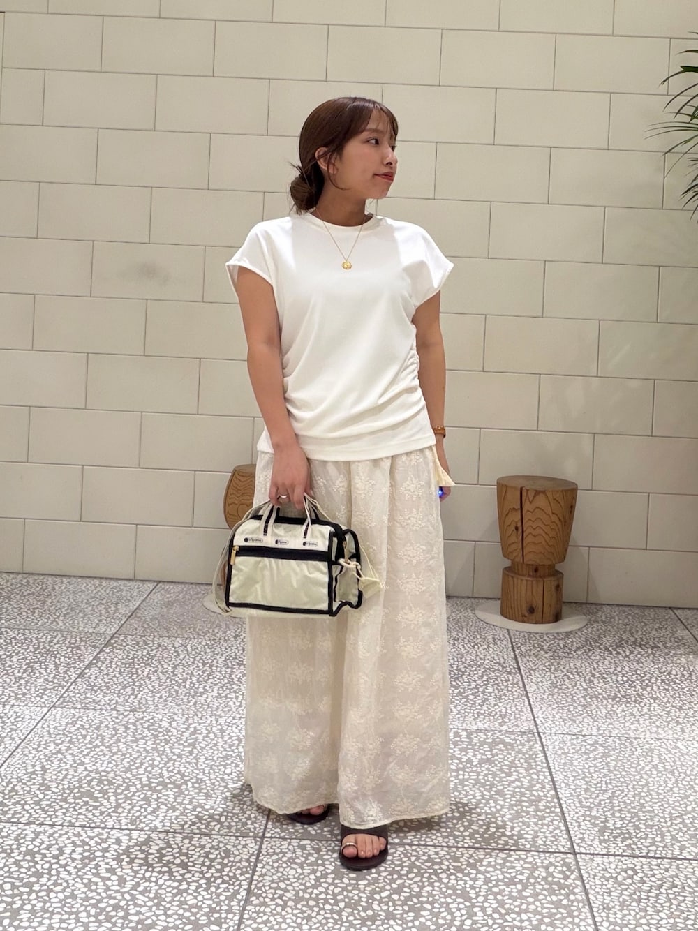 ホワイト系のTシャツ/カットソー、ベージュ系のショルダーバッグ、ホワイト系のスカートを着用したレディースの夏コーディネートの1枚目の写真