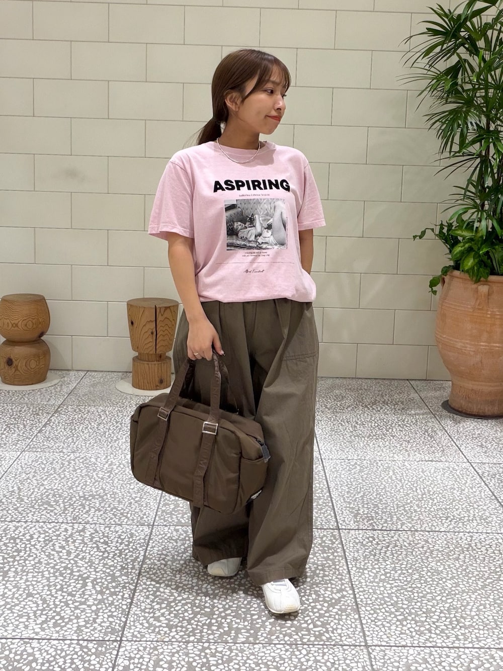 ピンク系のTシャツ/カットソー、グリーン系のその他パンツ、ブラウン系のボストンバッグを着用したレディースの夏コーディネートの1枚目の写真