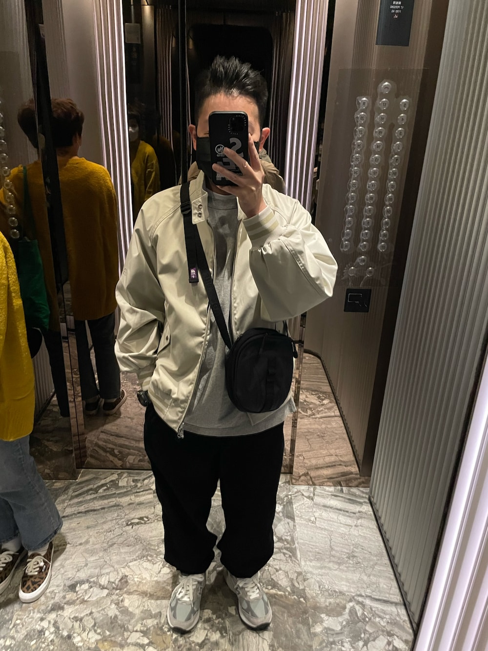 ブラック系のチノパンツ、グリーン系のダウンベスト、グレー系のその他トップスを着用したメンズの冬コーディネートの1枚目の写真