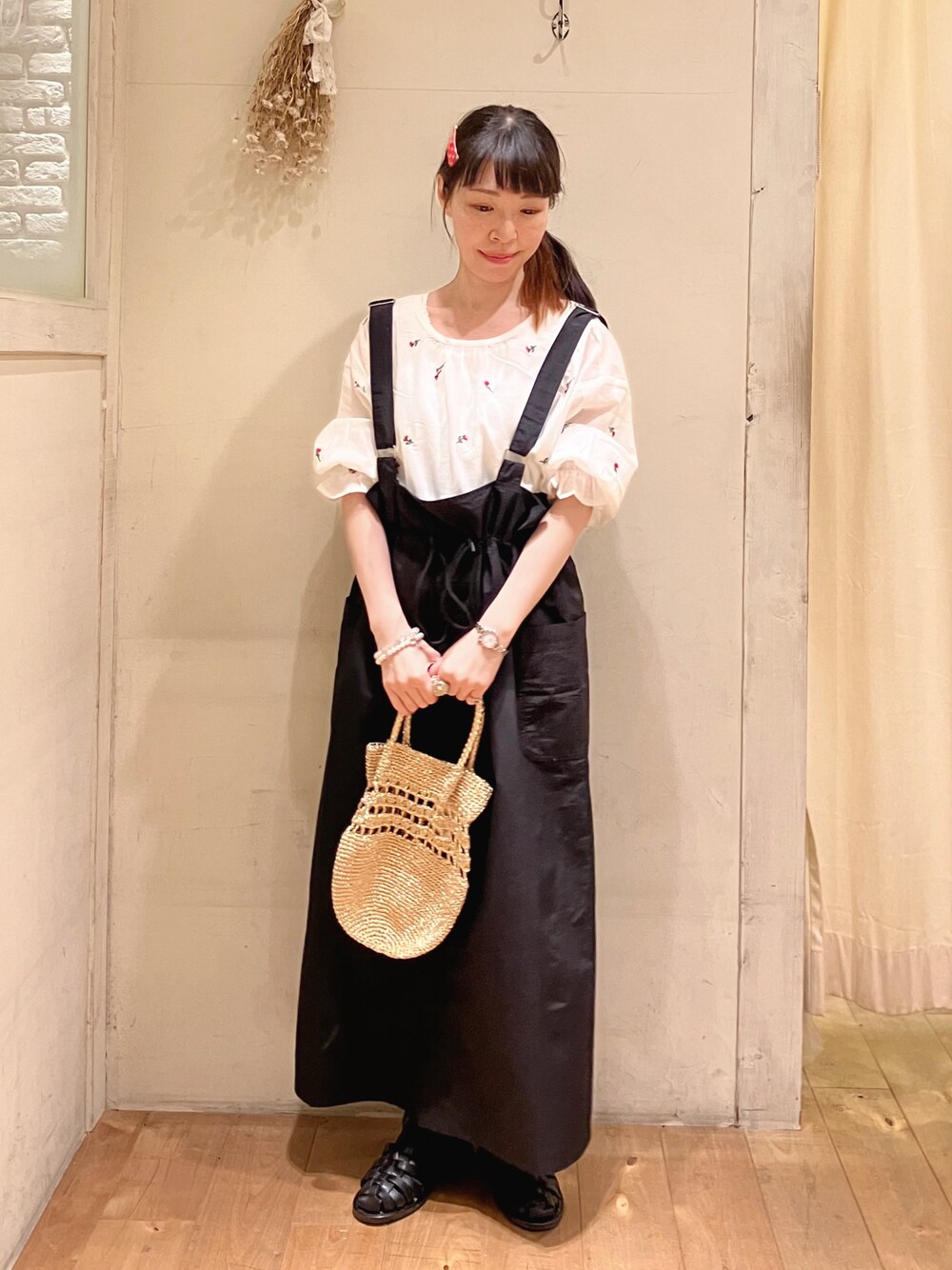 ホワイト系のシャツ/ブラウス、ブラック系のスカート、ゴールド系のハンドバッグを着用したレディースの春コーディネートの1枚目の写真