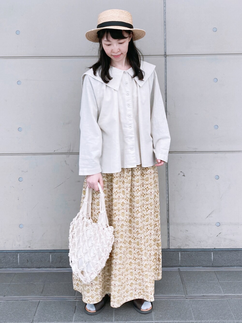ホワイト系のシャツ/ブラウス、ベージュ系のスカート、ホワイト系のハンドバッグを着用したレディースの夏コーディネートの1枚目の写真