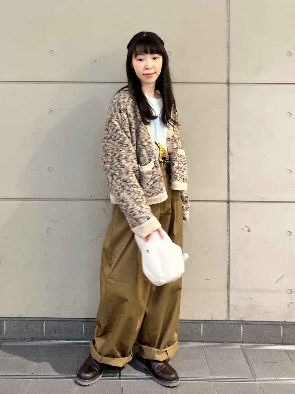 ブラウン系のサンダル、ベージュ系のカーディガン/ボレロ、ホワイト系のTシャツ/カットソーを着用したレディースの秋コーディネートの1枚目の写真