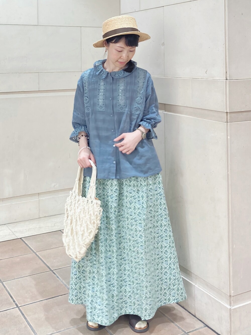 ブルー系のシャツ/ブラウス、ホワイト系のハンドバッグ、グリーン系のスカートを着用したレディースの夏コーディネートの1枚目の写真