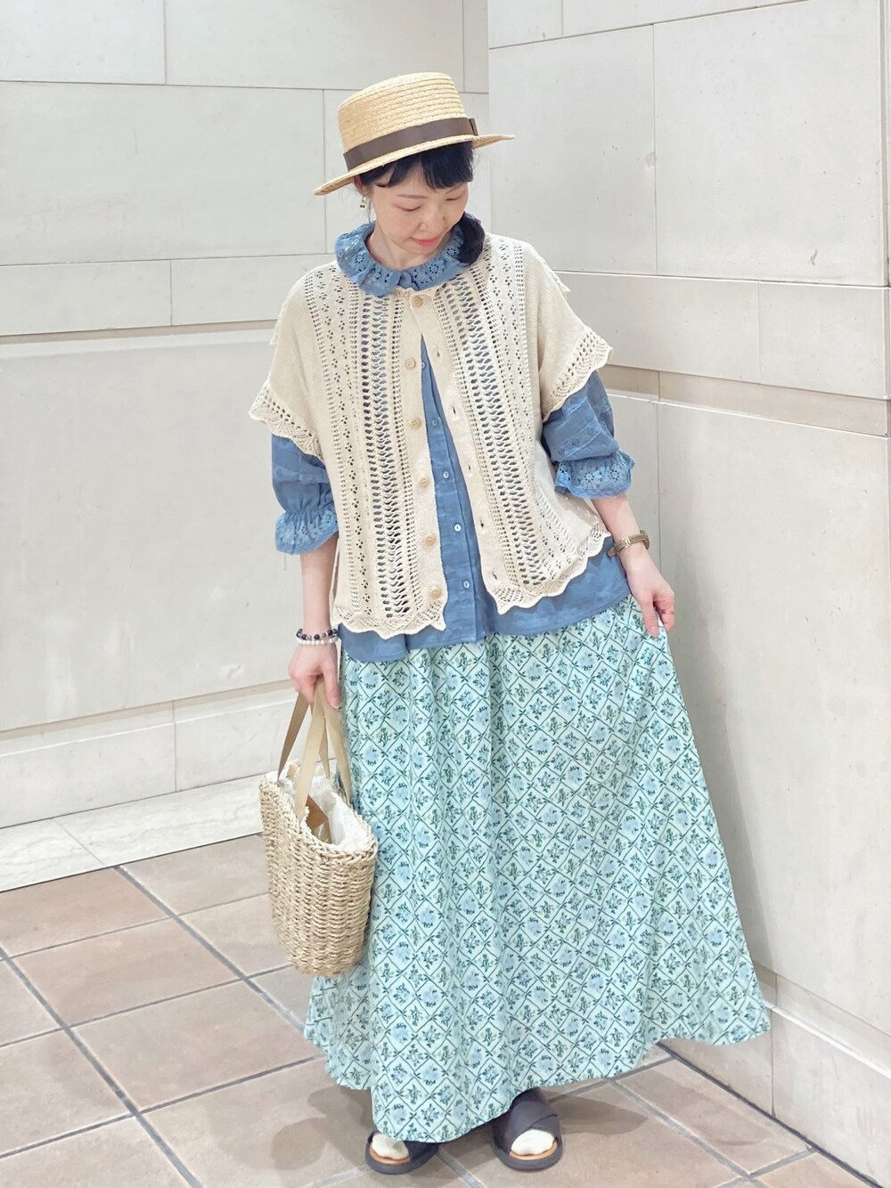 ブルー系のシャツ/ブラウス、ホワイト系のベスト、グリーン系のスカートを着用したレディースの春コーディネートの1枚目の写真