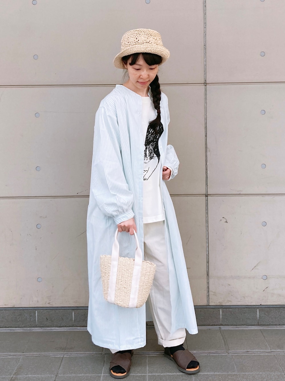 ブラウン系のサンダル、ホワイト系のTシャツ/カットソー、ホワイト系のハンドバッグを着用したレディースの春コーディネートの1枚目の写真