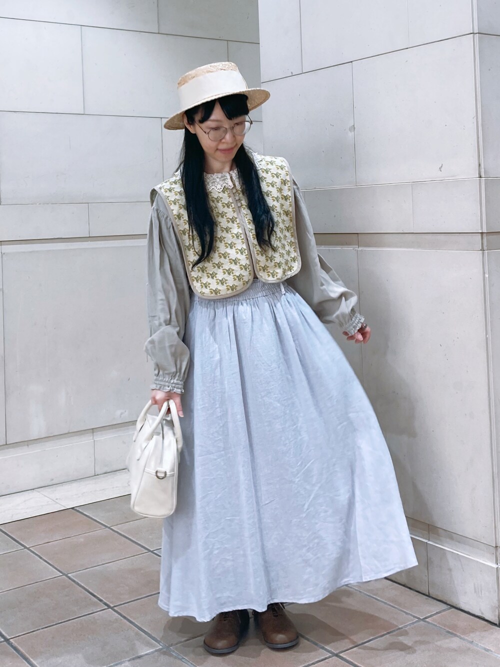 ベージュ系のベスト、ベージュ系のシャツ/ブラウス、ピンク系のスカートを着用したレディースの春コーディネートの1枚目の写真