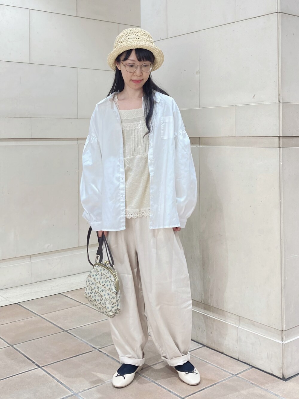 ホワイト系のシャツ/ブラウス、ベージュ系のTシャツ/カットソー、ホワイト系のハンドバッグを着用したレディースの春コーディネートの1枚目の写真