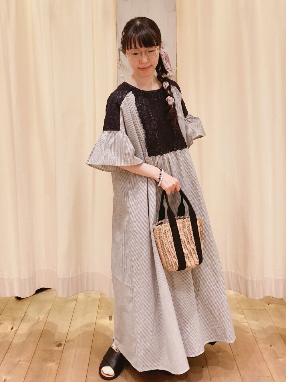 ブラック系のハンドバッグ、ブラック系のサンダル、ブラック系のワンピースを着用したレディースの春コーディネートの1枚目の写真