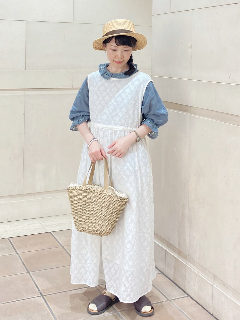 ブルー系のシャツ/ブラウス、ホワイト系のワンピース、ベージュ系のハンドバッグを着用したレディースの夏コーディネートの1枚目の写真
