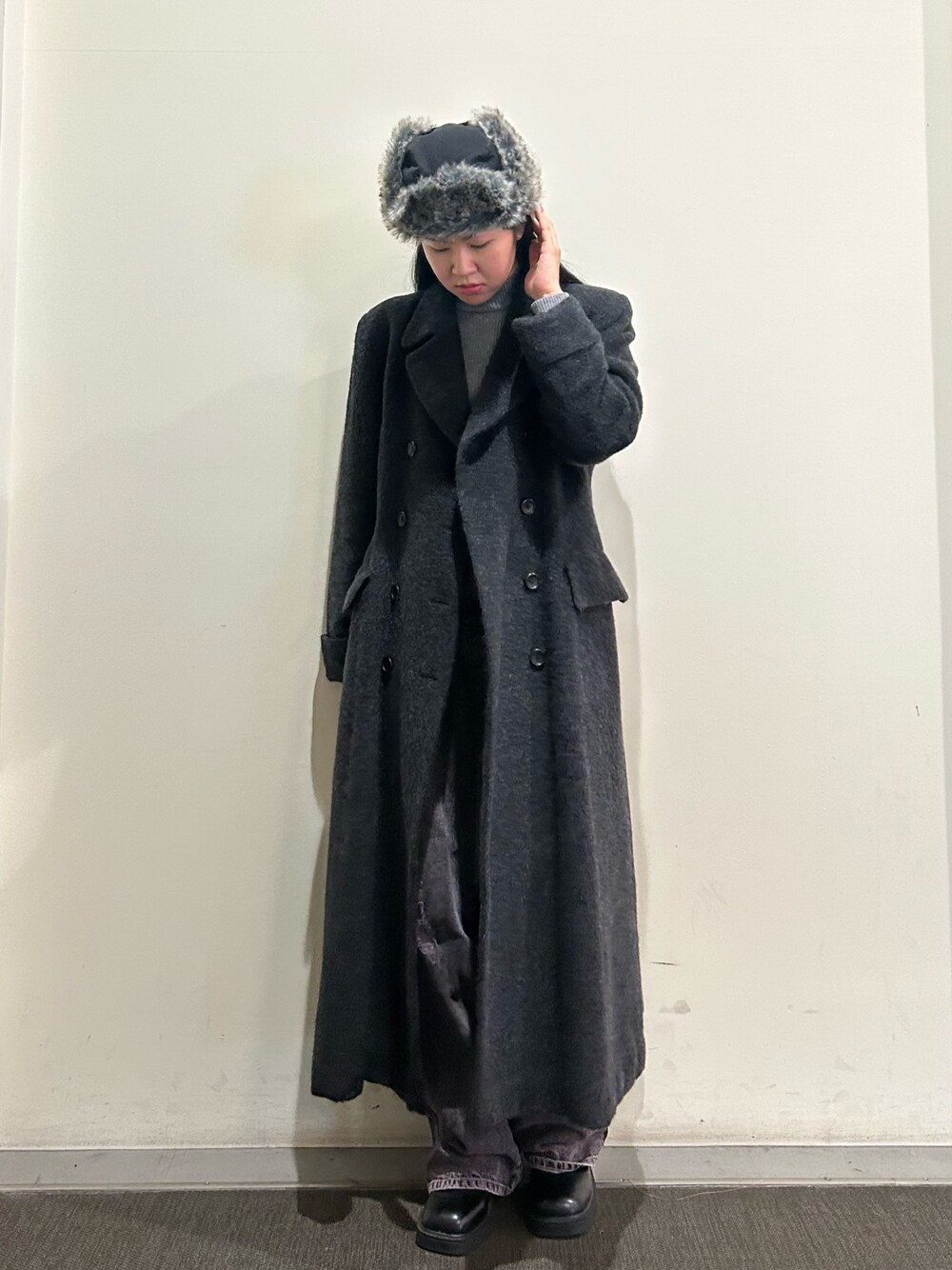 グレー系のジャケット/アウター、グレー系のニット/セーター、パープル系のデニムパンツを着用したレディースの冬コーディネートの1枚目の写真