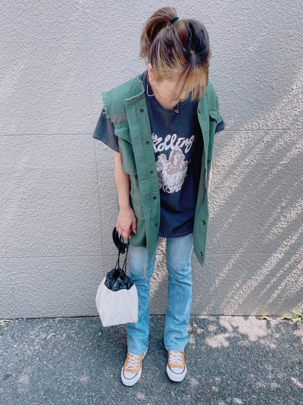 ブラック系のTシャツ/カットソー、グリーン系のその他アウター、ブルー系のデニムパンツを着用したレディースの秋コーディネートの1枚目の写真