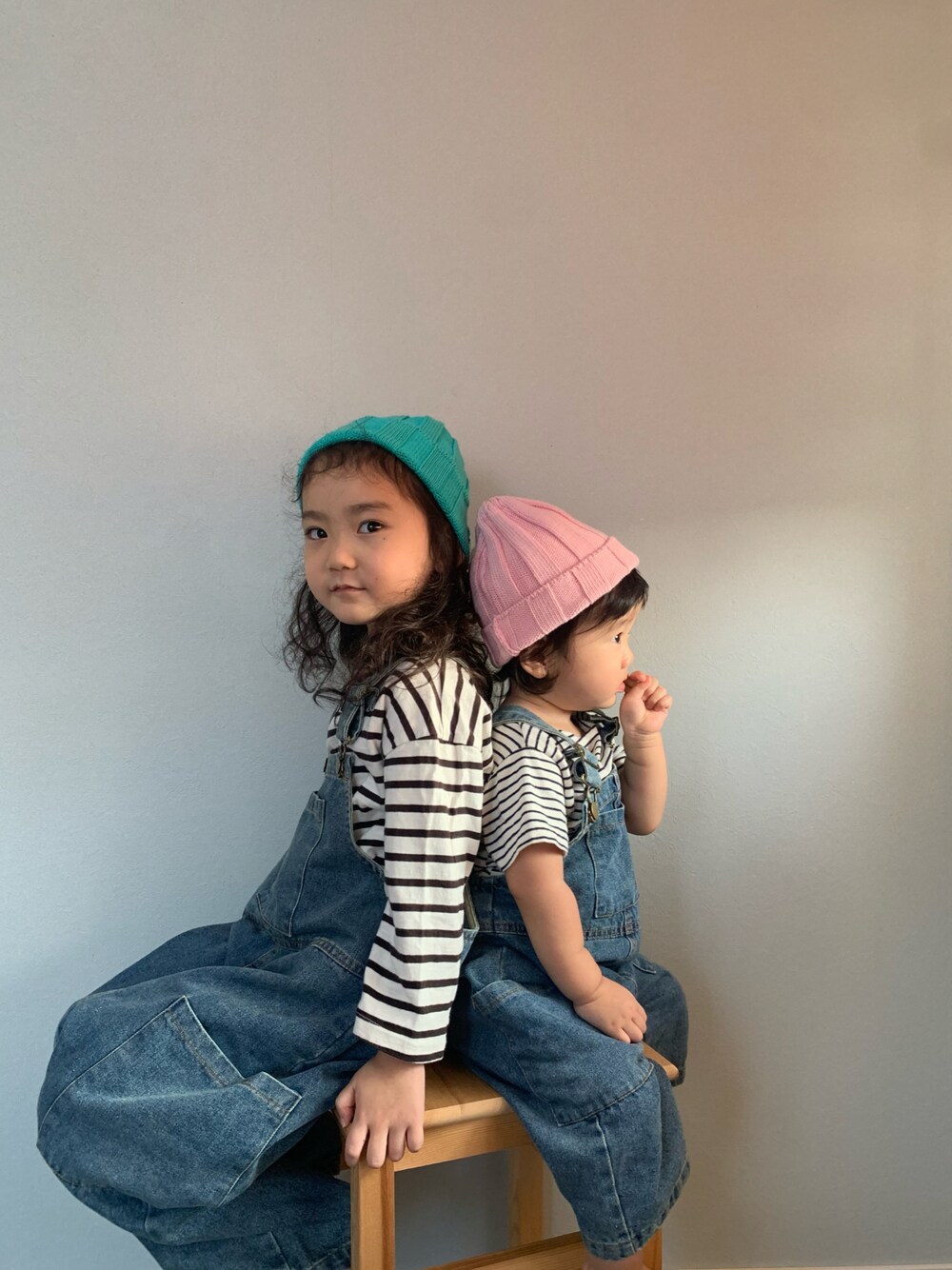 ブルー系のサロペット/オーバーオール、ホワイト系のTシャツ/カットソー、ピンク系のニットキャップ/ビーニーを着用したキッズの秋コーディネートの1枚目の写真