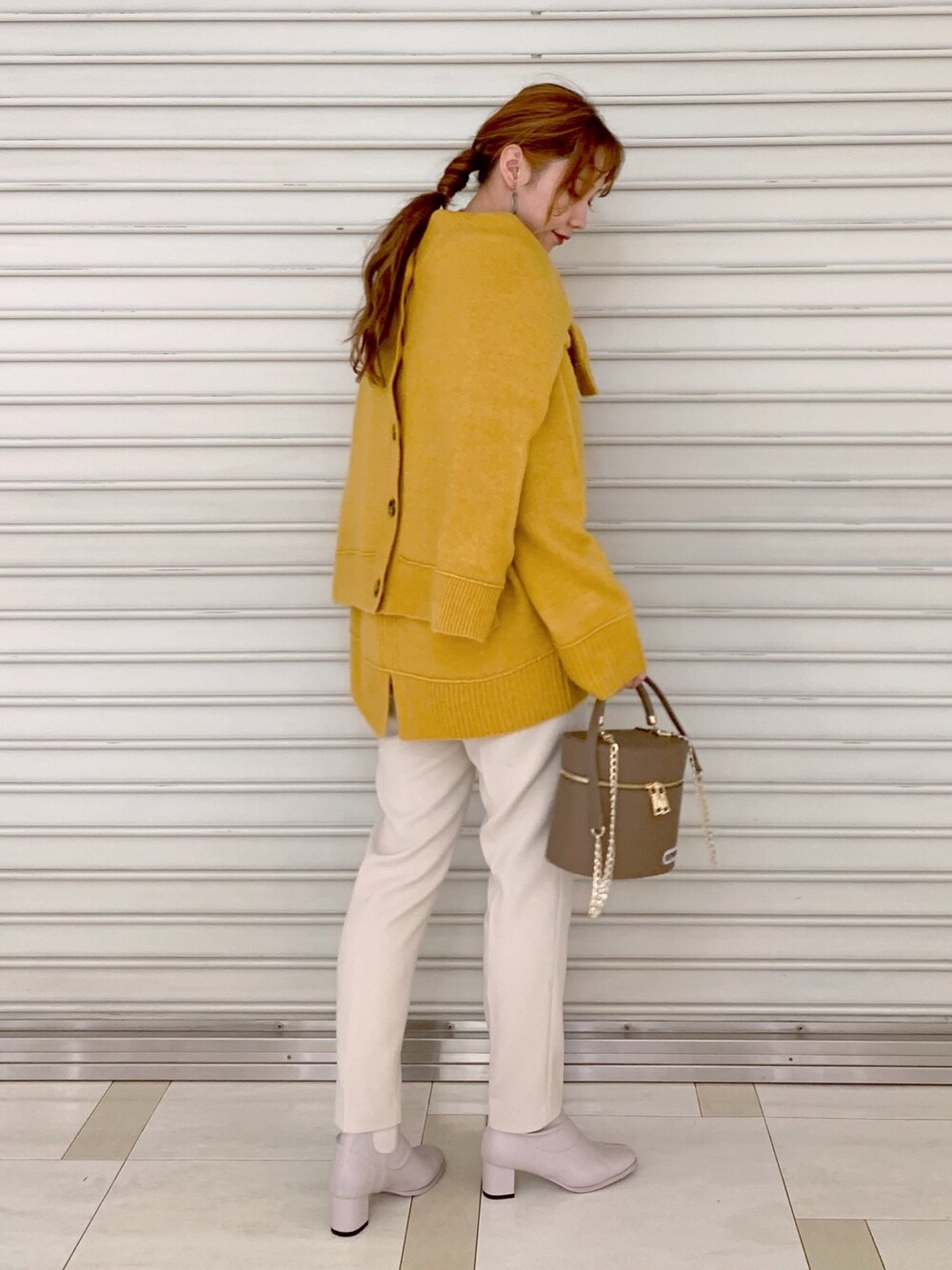 イエロー系のニット/セーター、イエロー系のカーディガン/ボレロ、イエロー系のその他パンツを着用したレディースの冬コーディネートの2枚目の写真