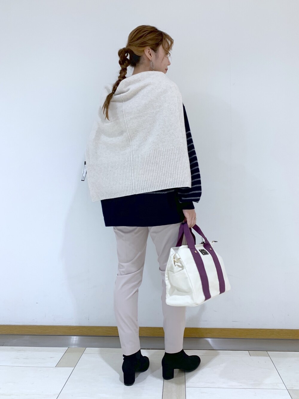 ブラック系のトップス、ベージュ系のニット/セーター、パープル系のトートバッグを着用したレディースの冬コーディネートの2枚目の写真