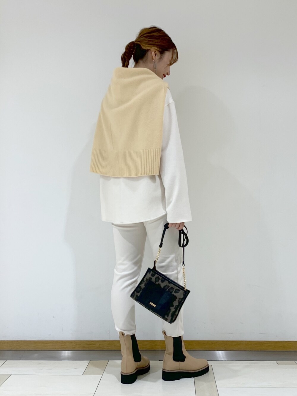 ホワイト系のトップス、イエロー系のニット/セーター、ホワイト系のパンツを着用したレディースの冬コーディネートの2枚目の写真