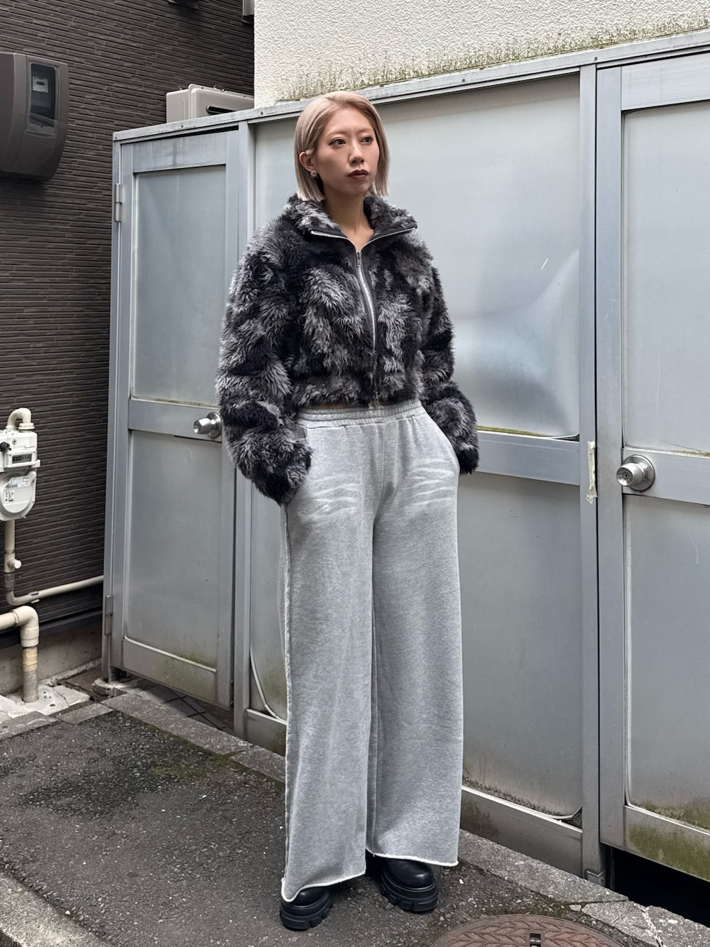 ブルー系のブルゾン、グレー系のスウェットパンツ、ブラック系のブーツを着用したレディースの秋コーディネートの1枚目の写真