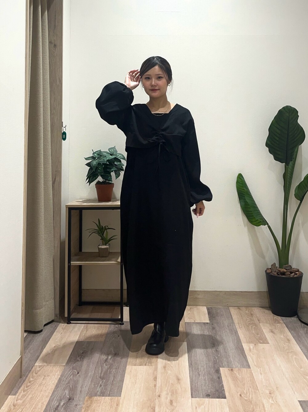 ブラック系のワンピース、ブラック系のブーツを着用したレディースの秋コーディネートの1枚目の写真