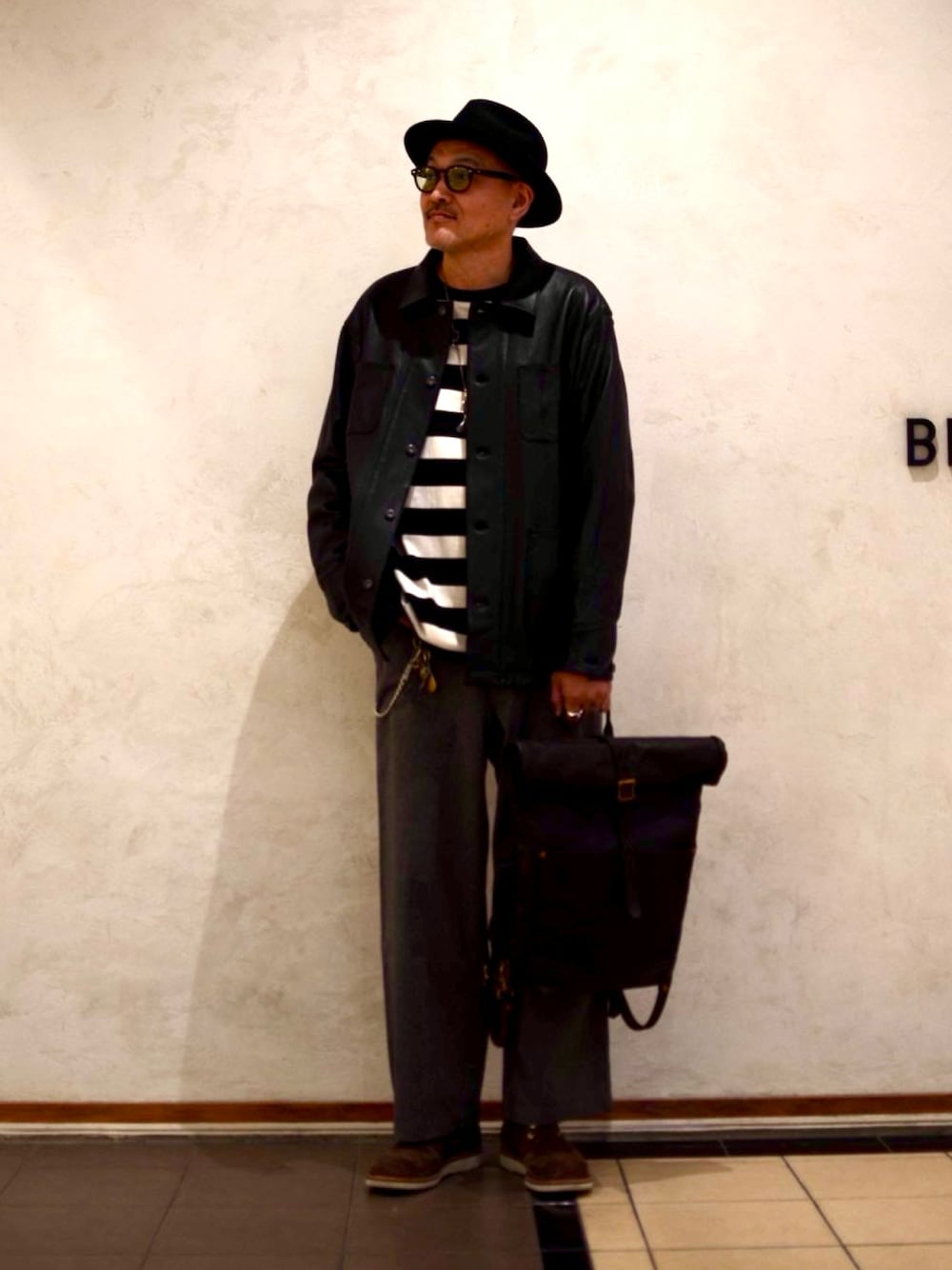 ブラック系のライダースジャケット、ブラック系のTシャツ/カットソー、ブラック系のバックパック/リュックを着用したメンズの春コーディネートの1枚目の写真