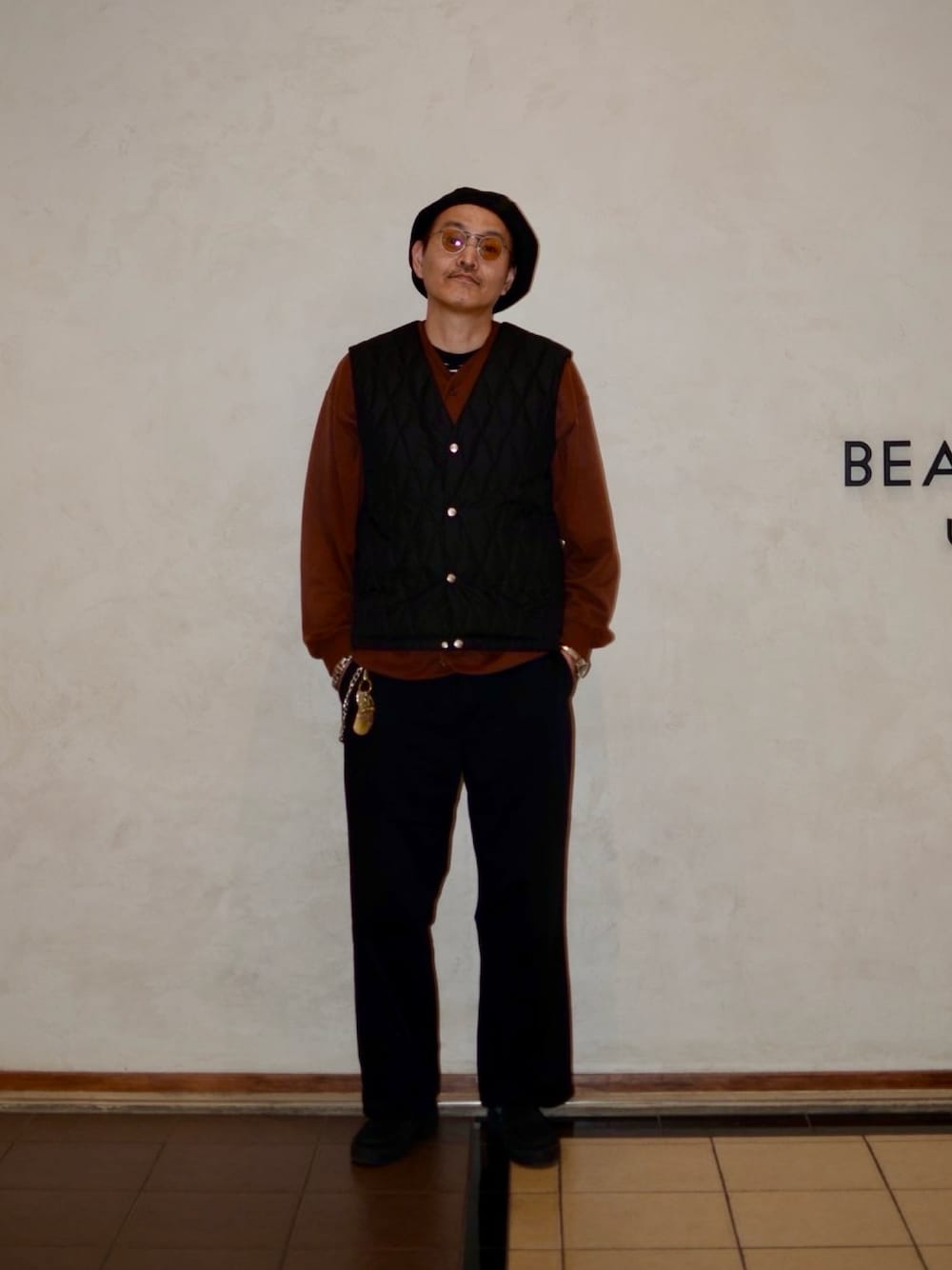 ブラウン系のカーディガン/ボレロ、ブラック系のダウンベスト、ブラック系のその他パンツを着用したメンズの秋コーディネートの1枚目の写真