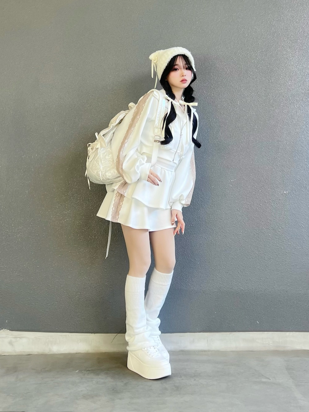 ホワイト系のシューズ、ホワイト系のジャージ、ホワイト系のスカートを着用したレディースの冬コーディネートの1枚目の写真