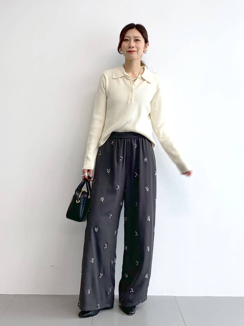 ブラック系のブーツ、ブラック系のボストンバッグ、グレー系のその他パンツを着用したレディースの冬コーディネートの1枚目の写真