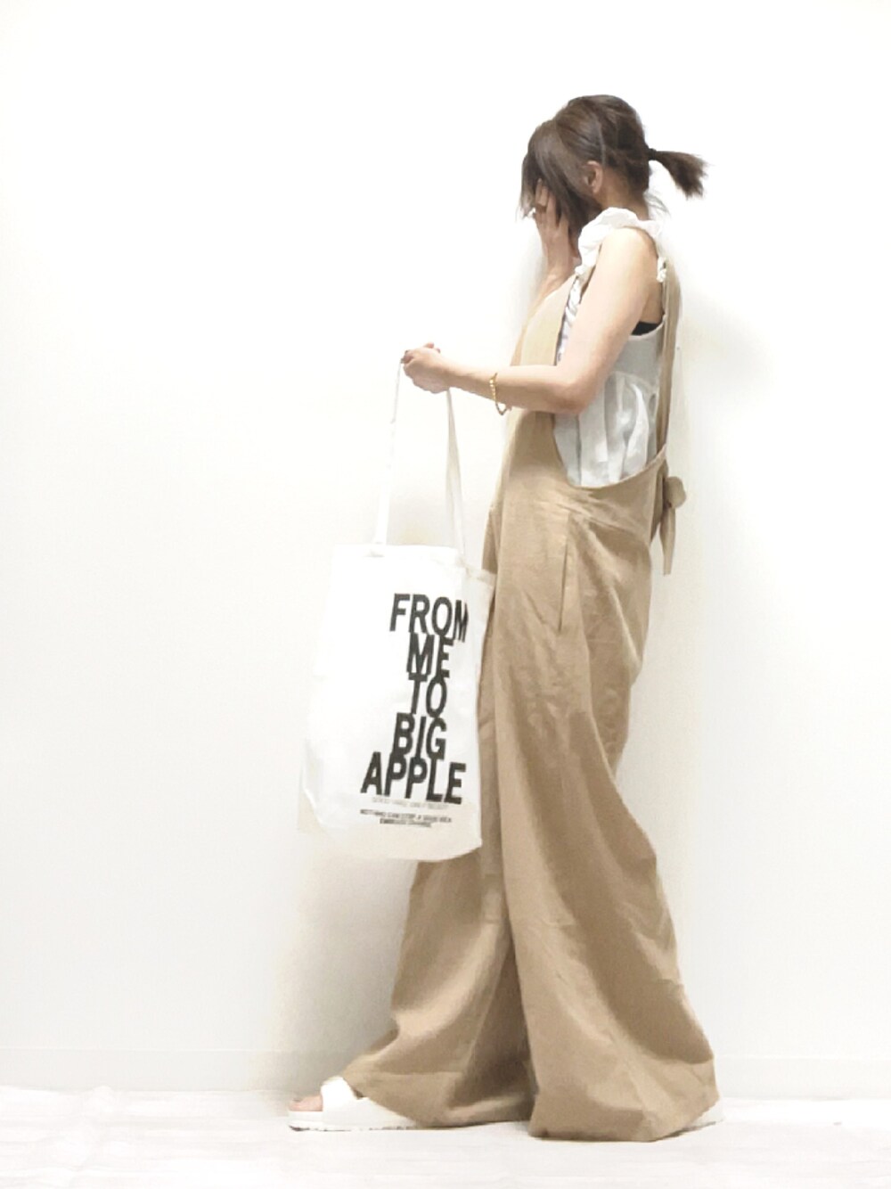 ベージュ系のサロペット/オーバーオール、ブラック系のトートバッグ、ホワイト系のサンダルを着用したレディースの夏コーディネートの1枚目の写真