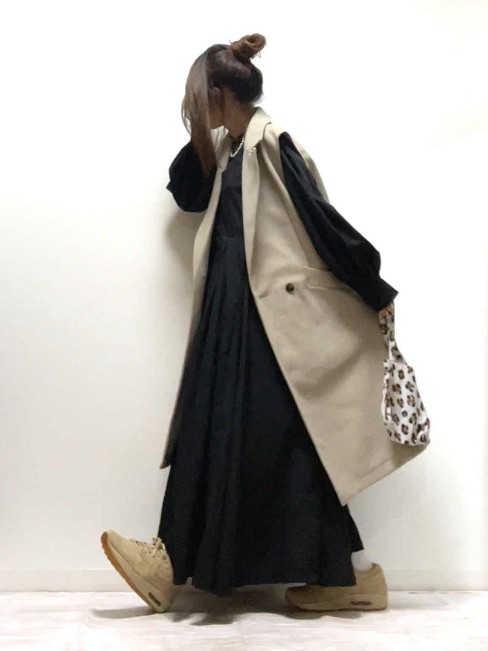 ブラック系のシャツワンピース、ベージュ系のベスト、ベージュ系のスニーカーを着用したレディースの秋コーディネートの1枚目の写真