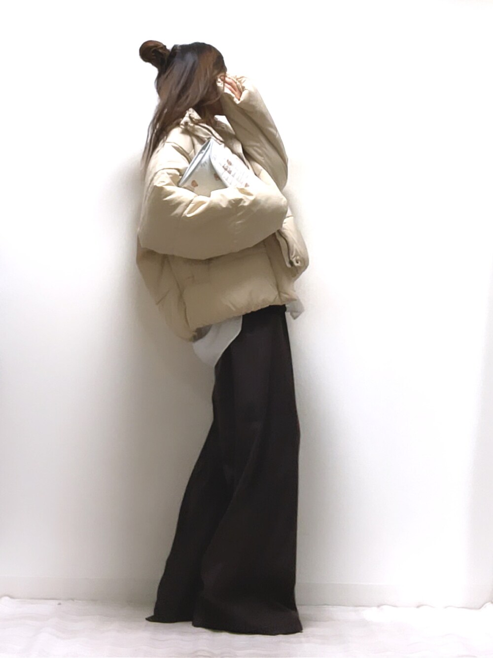 ホワイト系のダウンジャケット/コート、ブラウン系のカーディガン/ボレロ、ブラウン系のその他パンツを着用したレディースの冬コーディネートの1枚目の写真