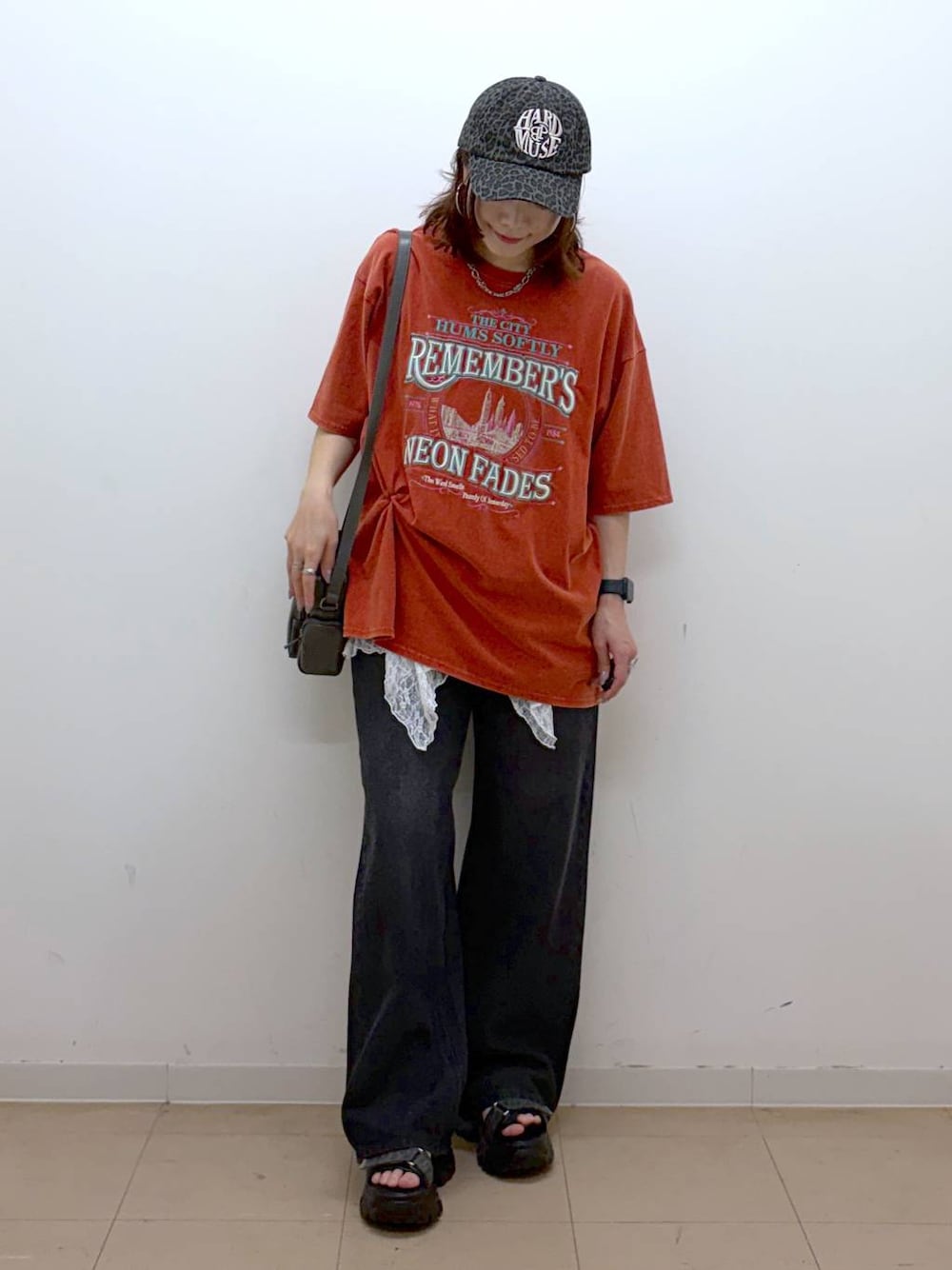 ブラック系のデニムパンツ、グレー系のショルダーバッグ、グレー系のサンダルを着用したレディースの春コーディネートの1枚目の写真