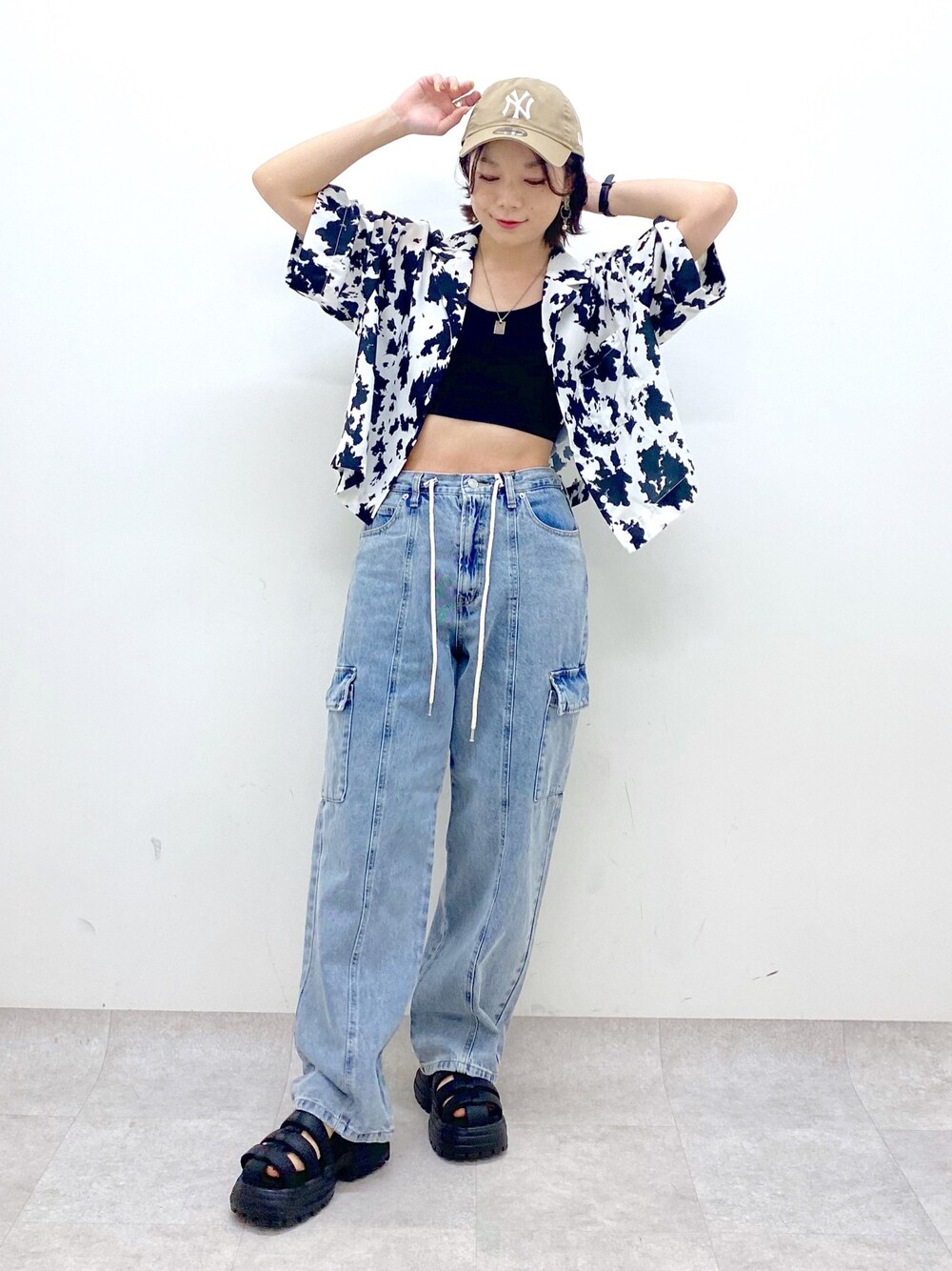 ブルー系のデニムパンツ、ブラック系のサンダル、ブラック系のトップスを着用したレディースの春コーディネートの1枚目の写真