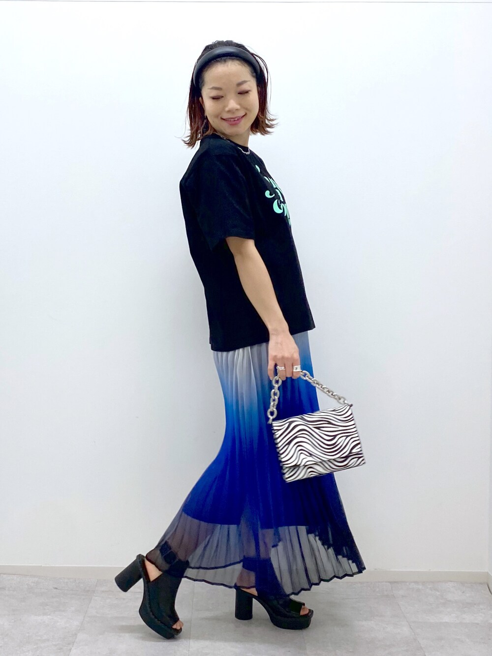 その他のショルダーバッグ、ブラック系のサンダル、ブルー系のスカートを着用したレディースの春コーディネートの1枚目の写真