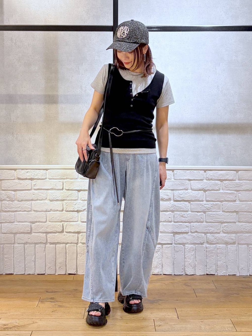 ブルー系のデニムパンツ、ブラック系のショルダーバッグ、ブラック系のサンダルを着用したレディースの春コーディネートの1枚目の写真