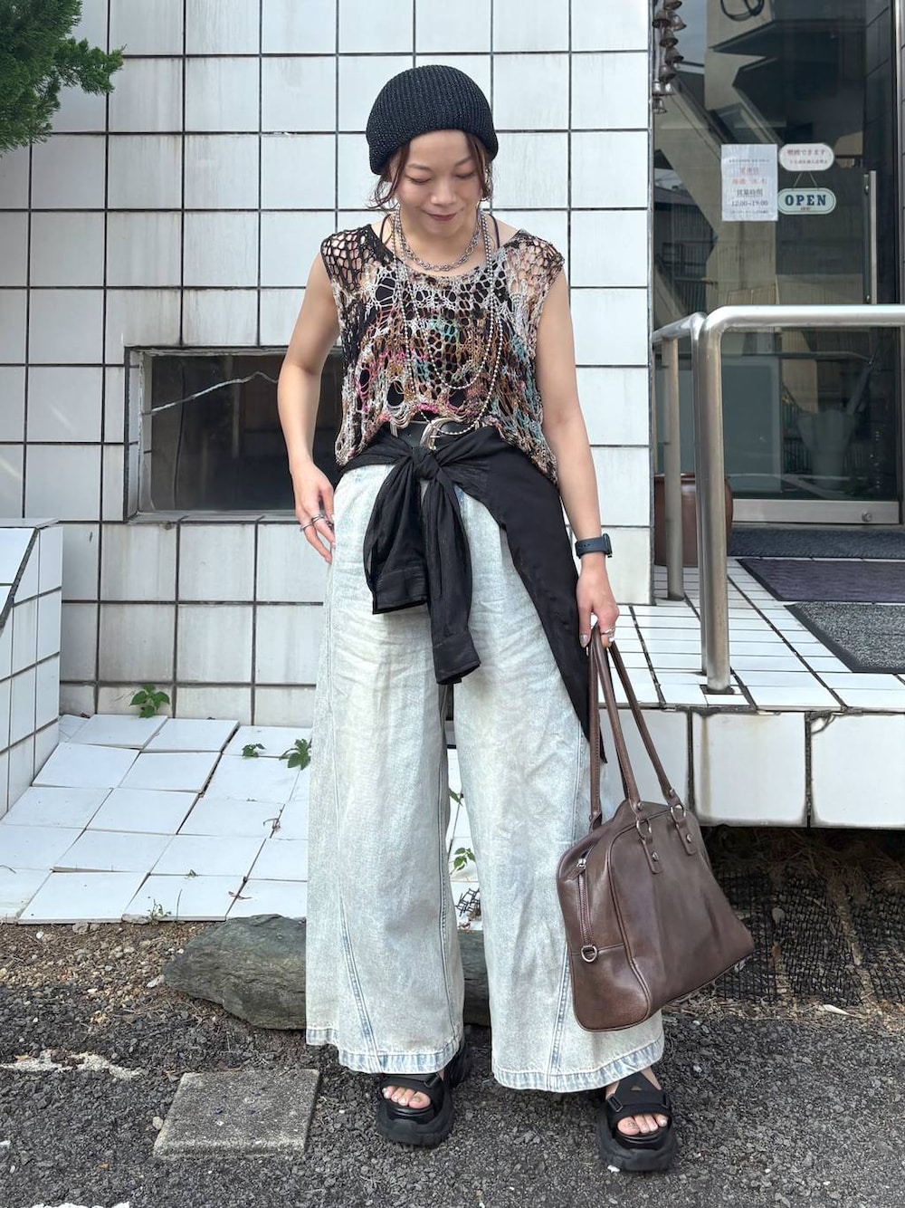 ブルー系のデニムパンツ、その他のベスト、ブラウン系のボストンバッグを着用したレディースの夏コーディネートの1枚目の写真
